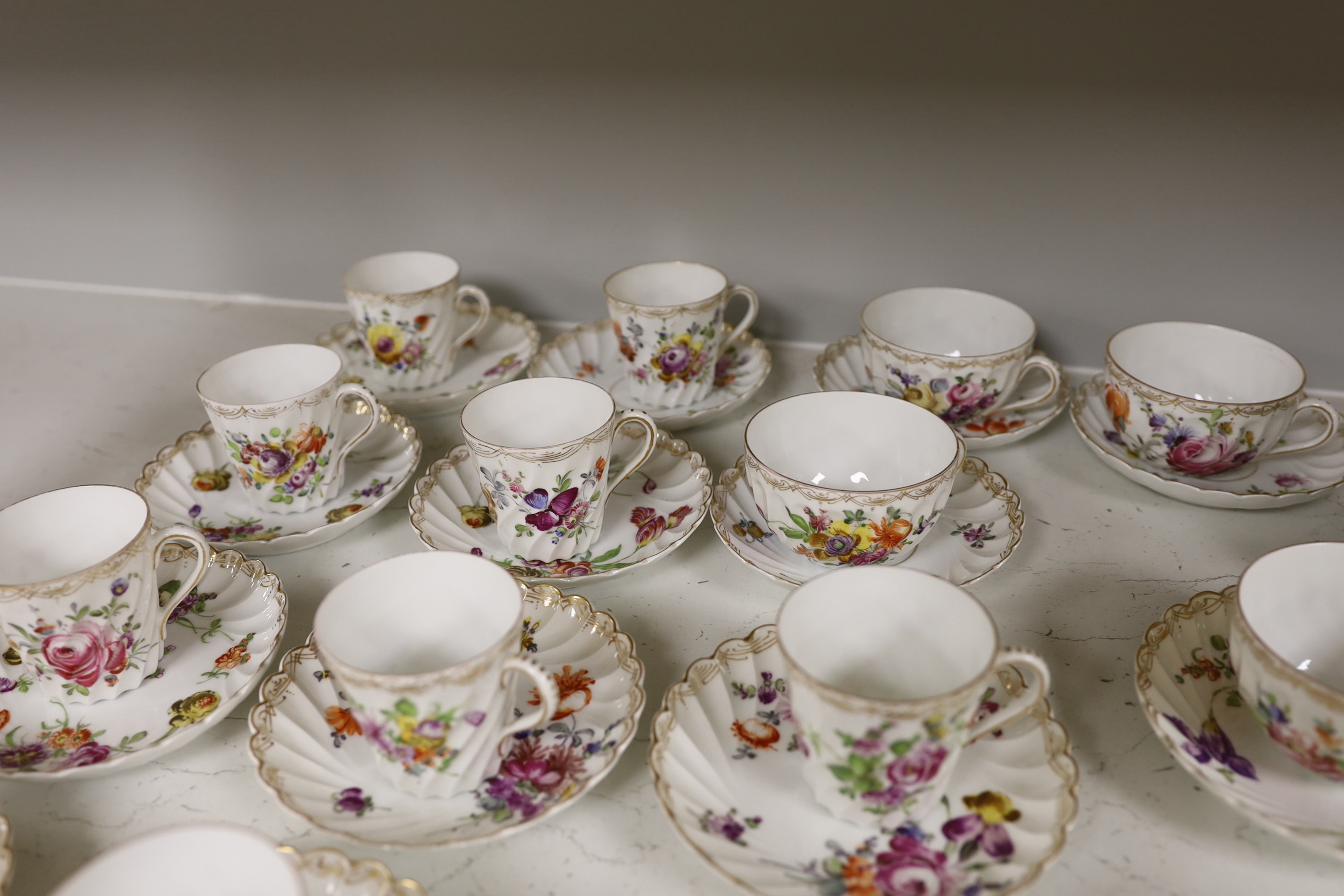 A group of porcelain Dresden tableware including cups and saucers and a blue and white jug